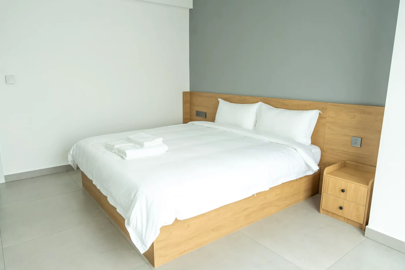 A clean modern hotel room with a neatly made bed